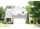 Charming two-story home with stone accents, a well-manicured lawn, and an attached two-car garage at 10726 Greenhead View Rd, Charlotte, NC 28262
