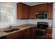 Functional kitchen featuring granite countertops, wood cabinets, and stainless steel appliances at 10726 Greenhead View Rd, Charlotte, NC 28262