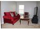 Cozy living room with plush red sofa, patterned armchair, and a dark wooden coffee table at 10726 Greenhead View Rd, Charlotte, NC 28262
