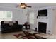 Comfortable living room showcasing a fireplace, ceiling fan, and natural light from large windows at 10726 Greenhead View Rd, Charlotte, NC 28262