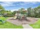 Community playground with slides, swings, and climbing structure surrounded by lush greenery and shade trees at 10726 Greenhead View Rd, Charlotte, NC 28262