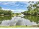 Scenic pond with a central fountain feature, reflecting the sky and surrounding trees, creating a tranquil community view at 10726 Greenhead View Rd, Charlotte, NC 28262