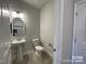 Stylish half bath with gray plank flooring, pedestal sink, and modern lighting fixture at 1110 Gardenia Dr # 6, Mt Ulla, NC 28125