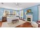 Tranquil bedroom with blue walls, wood floors, fireplace, and plenty of light at 117 N Mulberry St, Statesville, NC 28677