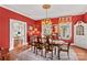 Classic dining room boasts red walls, vintage decor, hardwood floors, and a doorway to the kitchen at 117 N Mulberry St, Statesville, NC 28677