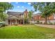 A view of a well-maintained house with a spacious front yard and mature trees, under a partly cloudy sky at 117 N Mulberry St, Statesville, NC 28677