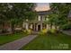 Inviting home with a stone walkway leading to a covered front porch, surrounded by lush landscaping at 117 N Mulberry St, Statesville, NC 28677