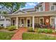 Inviting front porch with brick floor, columns, and seating, offering a relaxing outdoor space at 117 N Mulberry St, Statesville, NC 28677