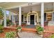 Charming covered porch with seating area, potted flowers, and stylish front door at 117 N Mulberry St, Statesville, NC 28677