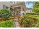 Inviting front porch with seating, lush landscaping, stone pathway, and classic home exterior at 117 N Mulberry St, Statesville, NC 28677