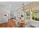 Bright eat-in kitchen features white cabinets, hardwood floors and natural light from large windows at 117 N Mulberry St, Statesville, NC 28677