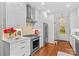Renovated white kitchen with stainless steel appliances and hardwood floors at 117 N Mulberry St, Statesville, NC 28677