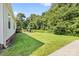 Side and backyard view with patio, yard, and wooded perimeter at 118 Grain Dr, Stony Point, NC 28678