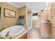 Well-lit bathroom featuring a soaking tub, neutral walls, and tiled flooring with a separate shower stall at 118 Grain Dr, Stony Point, NC 28678