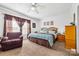 Cozy primary bedroom featuring a ceiling fan, warm-toned walls, and a sitting area near the window at 118 Grain Dr, Stony Point, NC 28678