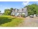 Bright, white two-story home with a large front yard, lush shrubbery, and dormer windows at 118 Grain Dr, Stony Point, NC 28678