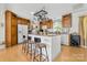 Eat-in kitchen featuring hardwood floors, an island with bar seating, white appliances and wood cabinets at 118 Grain Dr, Stony Point, NC 28678