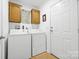 Functional laundry room with a washer, a dryer, ample storage cabinets, and an exterior door for convenience at 118 Grain Dr, Stony Point, NC 28678