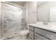 Bathroom featuring a white marble tiled shower, and modern white vanity with gray cabinetry at 11938 Fiddlers Roof Ln, Charlotte, NC 28277