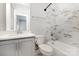 Modern bathroom featuring stylish marble tile, bathtub and shower combo, and gray vanity at 11938 Fiddlers Roof Ln, Charlotte, NC 28277