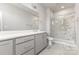 Bright bathroom featuring a double vanity and glass-enclosed shower with marble tile at 11938 Fiddlers Roof Ln, Charlotte, NC 28277