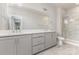 Bright bathroom featuring a double vanity and glass-enclosed shower with marble tile at 11938 Fiddlers Roof Ln, Charlotte, NC 28277
