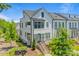 Charming three-story townhouse with white siding, black trim, and inviting landscaped front yard at 11938 Fiddlers Roof Ln, Charlotte, NC 28277