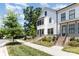 Inviting two-story townhome showcases brick accents, a well-maintained lawn, and lush trees at 11938 Fiddlers Roof Ln, Charlotte, NC 28277