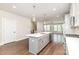 Open-concept kitchen offers a center island, stainless appliances, and hardwood flooring at 11938 Fiddlers Roof Ln, Charlotte, NC 28277