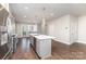 Stylish kitchen features an island with bar seating, hardwood floors, and modern lighting at 11938 Fiddlers Roof Ln, Charlotte, NC 28277