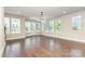 Open living room with hardwood floors, bright windows, and a modern light fixture at 11938 Fiddlers Roof Ln, Charlotte, NC 28277
