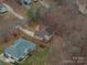 An aerial view of a brown house surrounded by trees in a quiet neighborhood at 122 Ardmore Pl, Mooresville, NC 28117