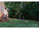 View of the yard from deck featuring a lush lawn with forest in background at 122 Ardmore Pl, Mooresville, NC 28117