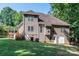View of the back of a tan home highlighting access to the outdoors and a well-maintained yard at 122 Ardmore Pl, Mooresville, NC 28117