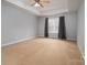 Bedroom with neutral walls, tray ceiling, ceiling fan and a large window at 122 Ardmore Pl, Mooresville, NC 28117