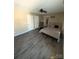 Bright bedroom featuring a metal bed frame, ceiling fan, and wood floors with an open doorway and closet entrances at 12564 Jessica Pl, Charlotte, NC 28269
