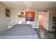 Cozy bedroom featuring wood floors and soft lighting, complemented by artwork and a door to an adjoining space at 12564 Jessica Pl, Charlotte, NC 28269