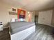 Comfortable bedroom features a gray bed with storage, wooden floors, and a view of the doorway and closets at 12564 Jessica Pl, Charlotte, NC 28269