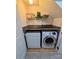 Compact laundry area with a washer, dryer, storage shelving, and counter space at 12564 Jessica Pl, Charlotte, NC 28269