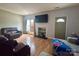 Cozy living room featuring hardwood floors, a large television, and comfortable seating at 12564 Jessica Pl, Charlotte, NC 28269