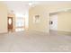 Open-concept living area with a kitchen view, neutral carpet, and an inviting atmosphere at 1271 Applewood Ln, York, SC 29745