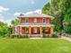 Charming two-story red brick home with a covered porch and manicured lawn at 128 W End St, Chester, SC 29706
