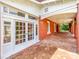 A brick-paved porch with white trim, red brick columns, and a glimpse of lush greenery at 128 W End St, Chester, SC 29706
