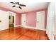 Bright bedroom featuring hardwood floors, pink walls, and multiple doors creating an open and inviting space at 14115 Old Statesville Rd, Huntersville, NC 28078