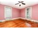 Charming bedroom featuring hardwood floors, pink walls, and plenty of natural light from the well-placed windows at 14115 Old Statesville Rd, Huntersville, NC 28078