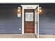 Close-up of front door with a glass window and stylish brown wood design at 14115 Old Statesville Rd, Huntersville, NC 28078