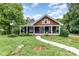 Charming home featuring a covered front porch, brown shingles, and a well-maintained yard at 14115 Old Statesville Rd, Huntersville, NC 28078