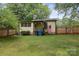 Back of home featuring mature trees, fenced yard and American flag on porch at 1425 3Rd Street Ne Pl, Hickory, NC 28601