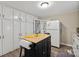 This kitchen boasts an island with a wood countertop, complemented by abundant white cabinets and appliances at 1425 3Rd Street Ne Pl, Hickory, NC 28601