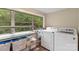 Bright laundry room featuring large window with serene view and modern washer/dryer units at 1425 3Rd Street Ne Pl, Hickory, NC 28601